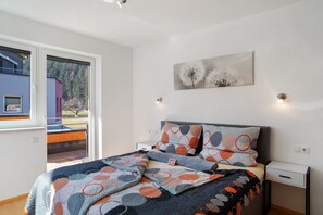 A bedroom with a bed, a nightstand, a window, and a painting on the wall. - Holiday Apartment 'Apart Annabell' with Mountain View, Private Terrace and Wi-Fi (Oetz)