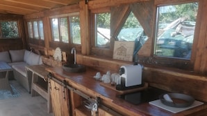 L’intérieur d’une cabane en bois comprend un coin cuisine, une table à manger et un canapé.