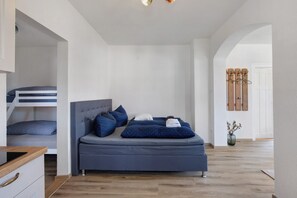 A bedroom with a bed, a wardrobe, and a door. - Holiday Apartment 'Romantika - Fewo Og Rechts' with Shared Garden, Balcony and Wi-Fi (Ichenhausen)