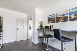 Une cuisine moderne avec une porte blanche, un coin café et une vue sur la plage par la fenêtre.