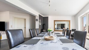 Un comedor con una mesa larga, sillas negras y un centro decorativo.