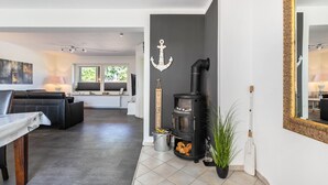 Una sala de estar moderna con chimenea, un sofá, una mesa de comedor y un espejo grande.