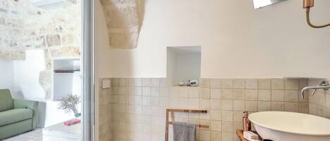 Une salle de bain avec un grand lavabo ovale, un porte-serviettes et un miroir.