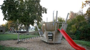 Ein Spielplatz mit Rutsche und Schaukeln.