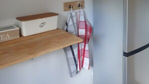 A kitchen with wooden shelves, a refrigerator, and kitchen towels. - Hestihof – Icelandic Horse Farm and Holiday Apartment (Waldburg)
