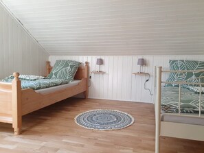 Une chambre avec un lit en bois, un tapis rond et un plafond blanc.