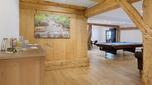 A wooden interior with a pool table, a reception desk, and a painting of a stream. - Apartment 'Bauernstüble' with Mountain View, Shared Terrace and Wi-Fi (Gutach (Schwarzwaldbahn))