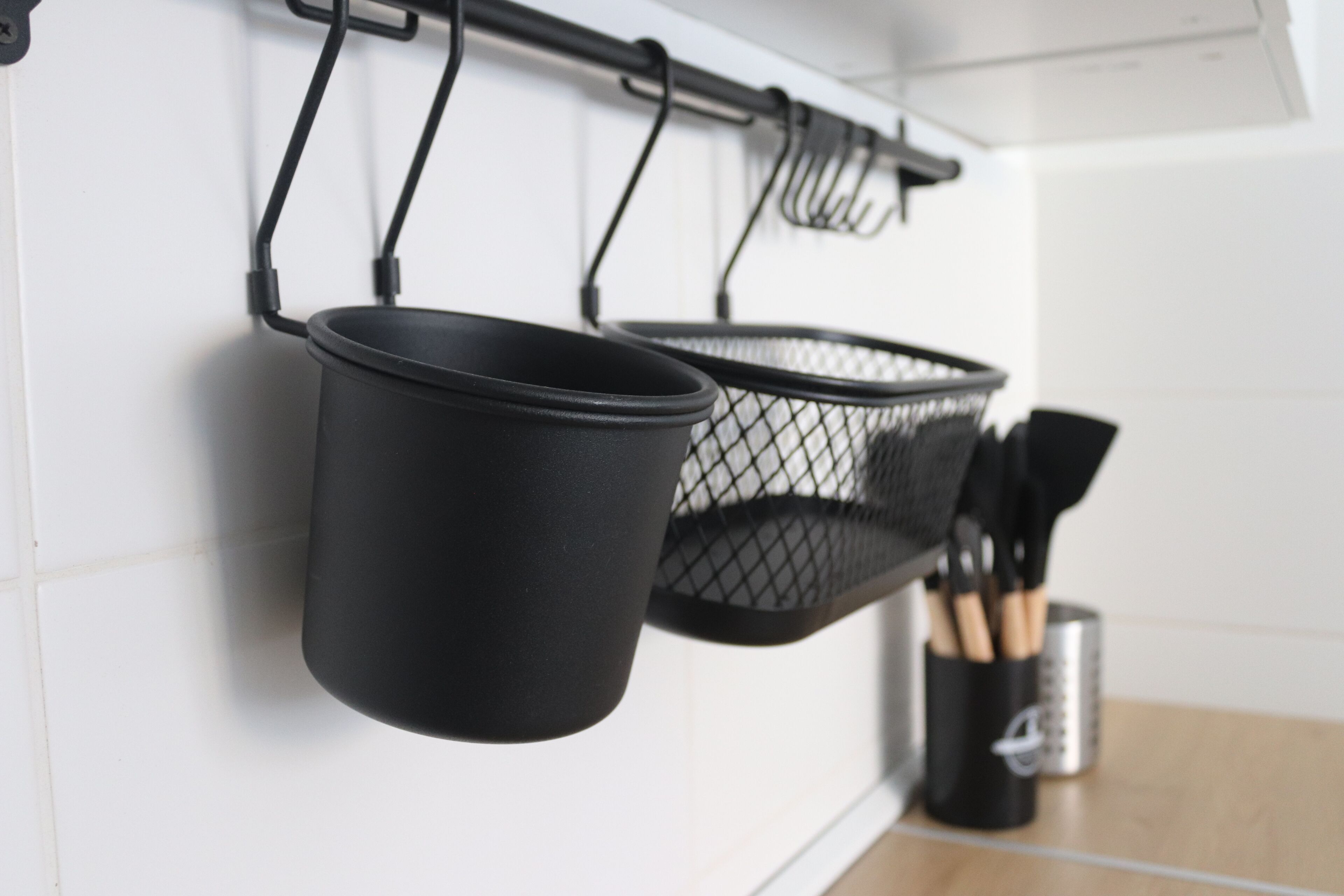 Uma cozinha com panelas penduradas e um porta-utensílios.