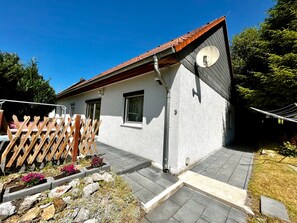 A house with a tiled roof, a satellite dish, and a wooden fence.