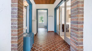A hallway with brick walls, a wooden ceiling, and patterned floor tiles. - Apartment 'Obendrot' with Shared Terrace, Shared Garden and Wi-Fi (Nordstrand)