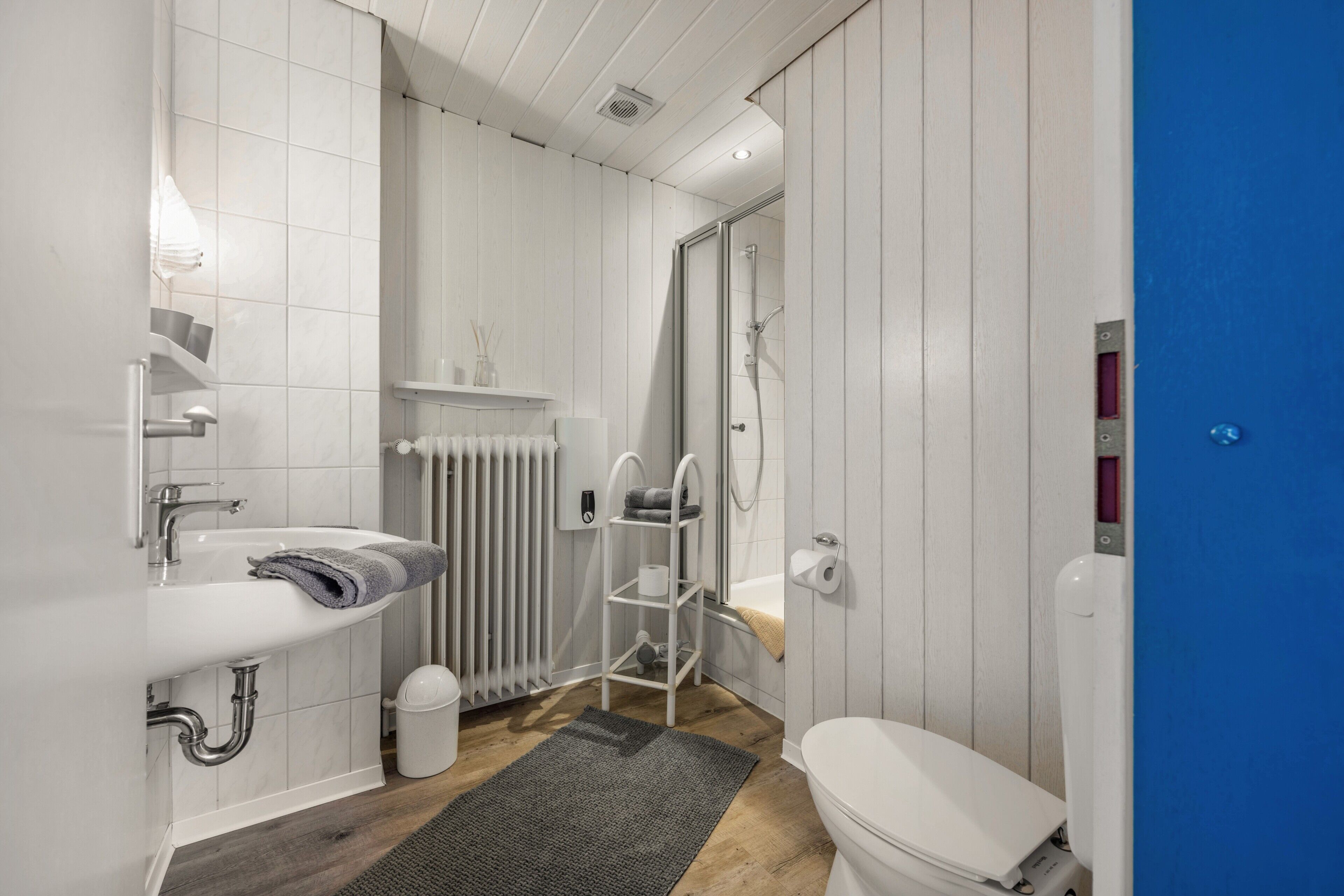 A modern bathroom with a white sink, toilet, and shower.