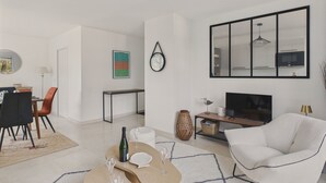 Un salon moderne comprenant un coin repas, un grand miroir et un téléviseur à écran plat.
