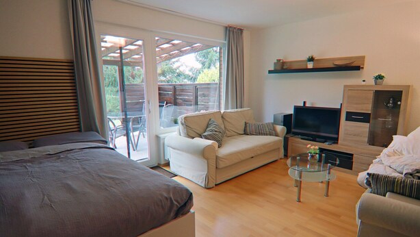 Een moderne woonkamer met een bank, een televisie en een glazen salontafel.