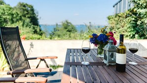 Puisesta pöydästä löytyy kaksi viinilasia ja viinipullo, tuoli, lyhty ja kukkakimppu.