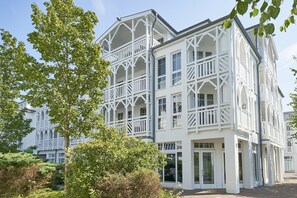 A multi-story building with a symmetrical facade, large windows, and a balcony on the upper floors. - Ferienwohnungen im Seepark Sellin (Sellin)