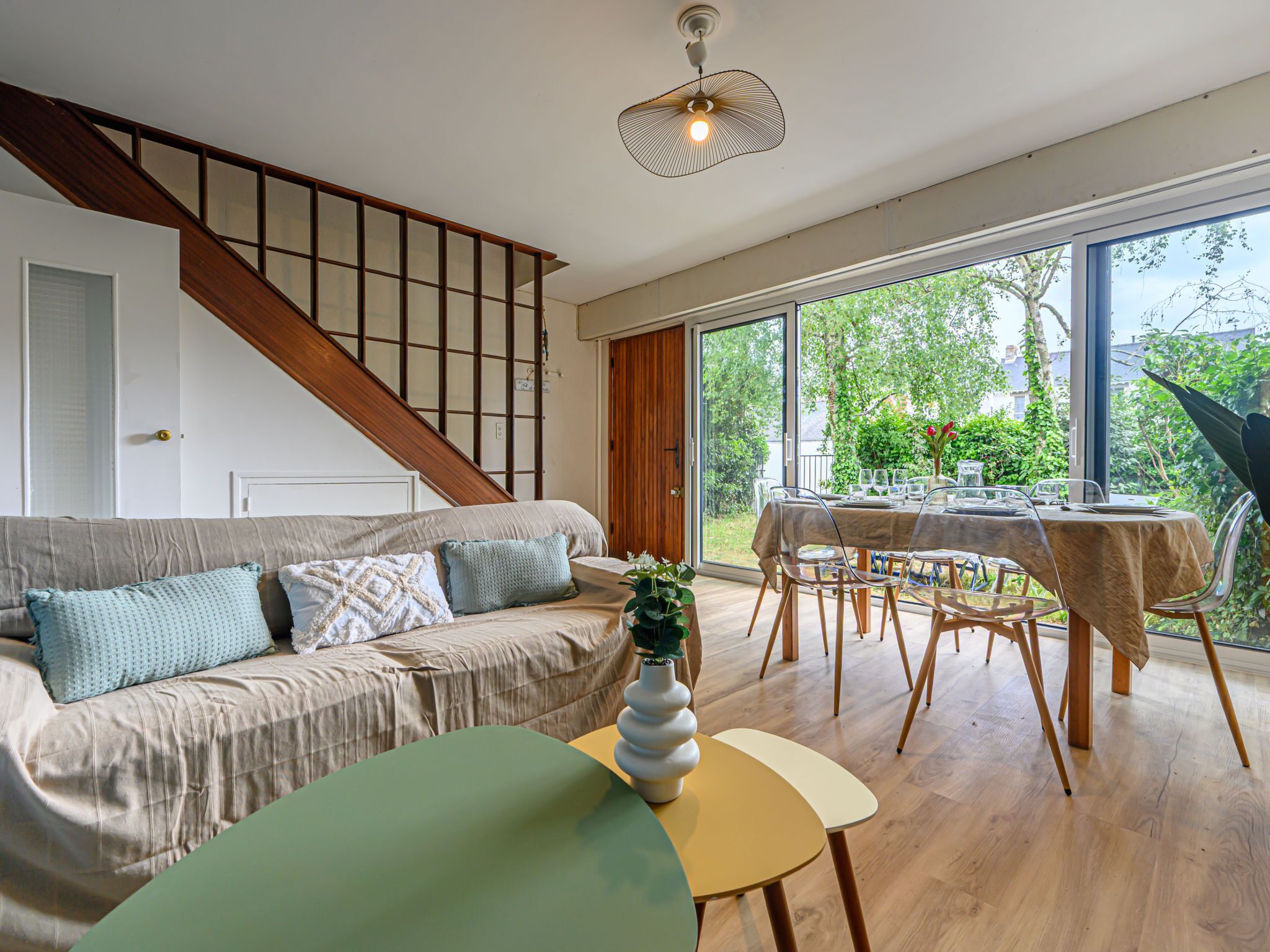 Un salon moderne avec un canapé, une table à manger et un escalier.