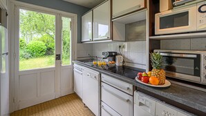 A compact kitchen with white cabinets, a microwave, a toaster, and a sink.