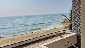 A balcony with a view of the beach and ocean.