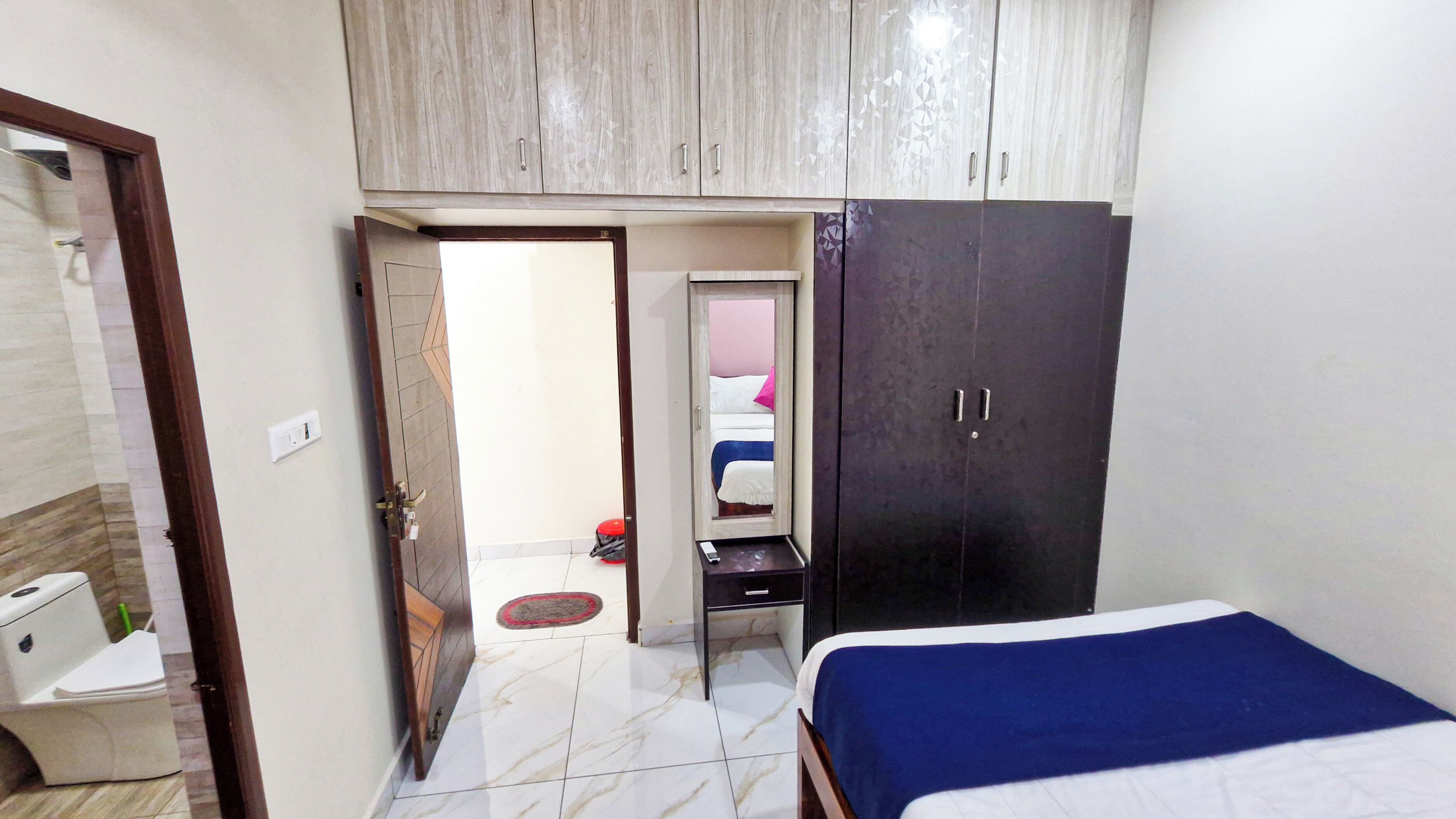 Una camera da letto con un letto, un armadio e un bagno con il water e un lavandino.
