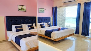 A double bed with a dark headboard, white bedding, and a blue accent pillow.