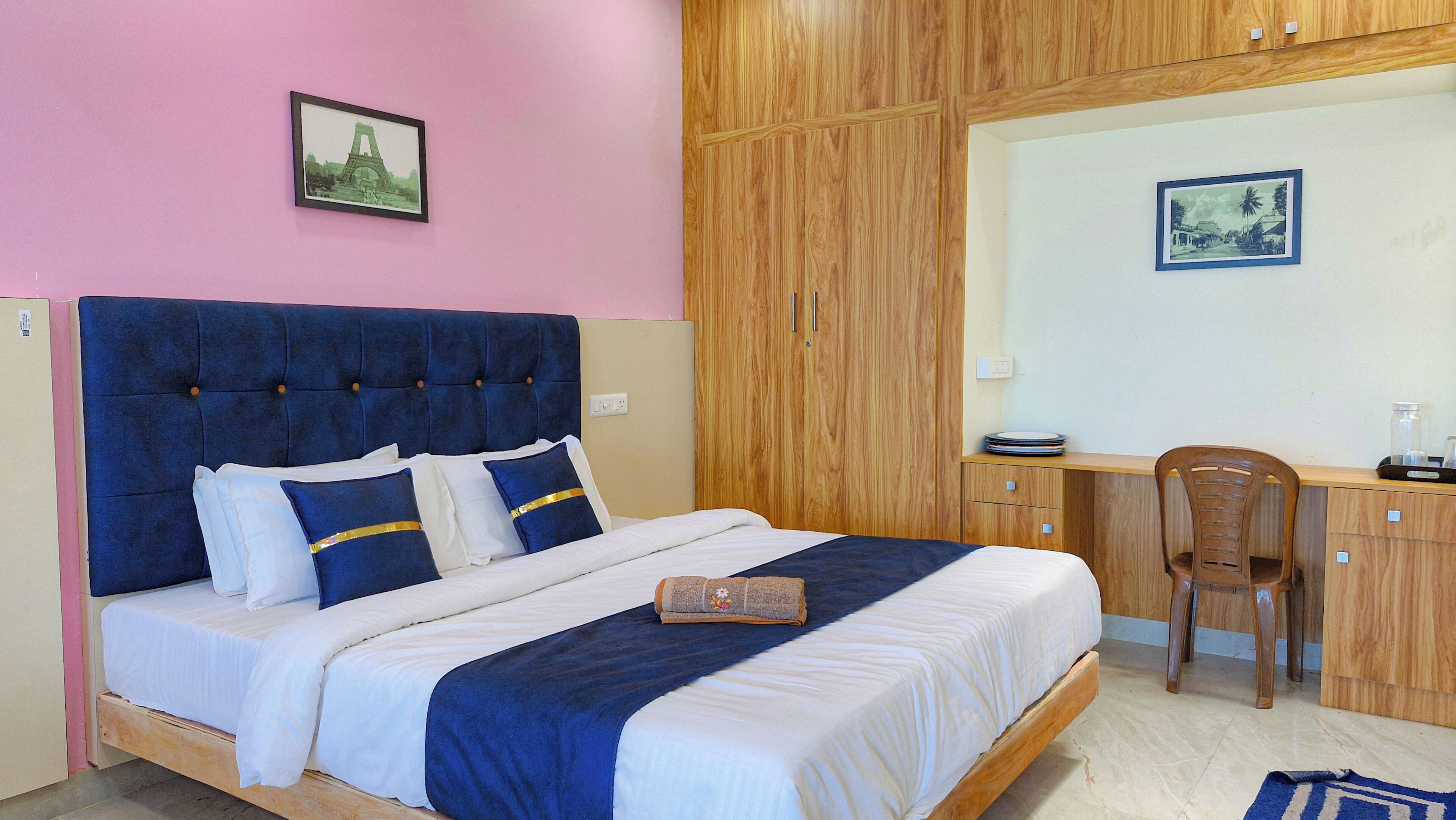 A bedroom with a bed, a desk, and a chair.