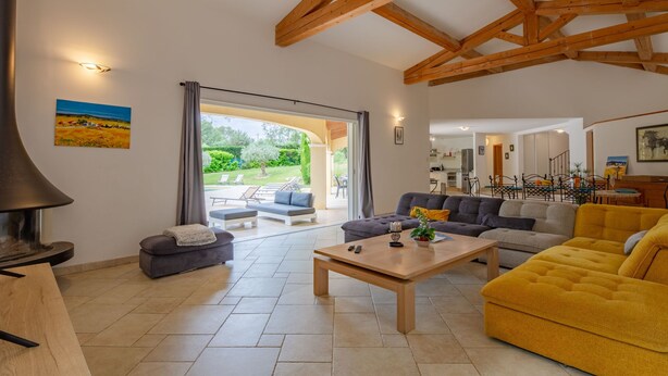 A spacious living area with a fireplace, a sofa, a yellow armchair, and a dining table. - La Pimaleanne by Interhome (Roquefort les Pins)