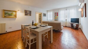 A dining area with a table set for four, a television, and artwork on the walls. - Lido Versilia by Interhome (Lido di Camaiore)
