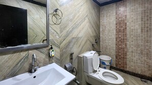 A bathroom with a sink, toilet, and mirror. - Hotel Florence Legacy (New Delhi)