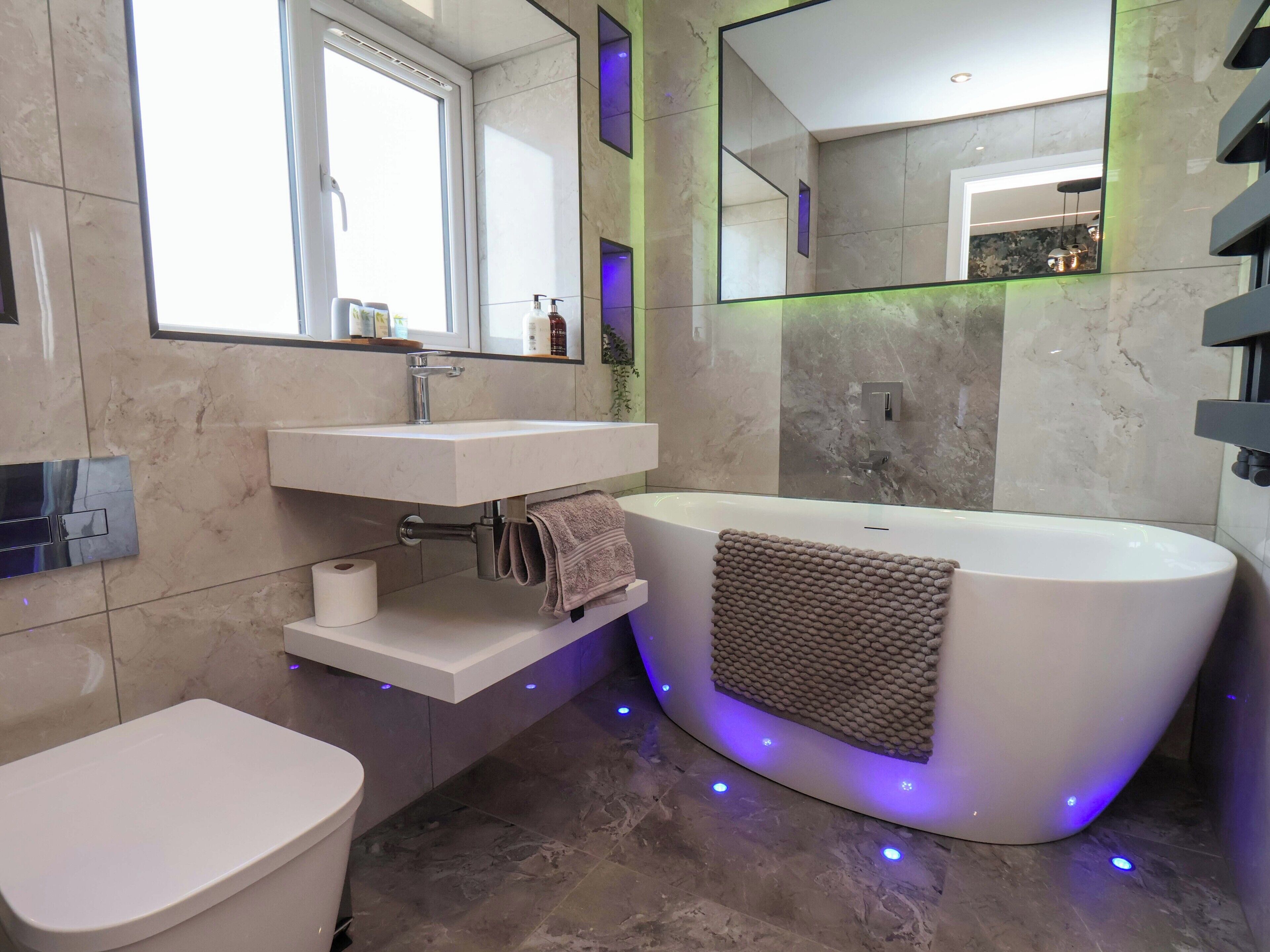 Ein modernes Badezimmer mit einer freistehenden Badewanne, einem eingebauten Waschbecken und einer Toilette.