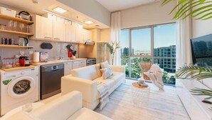 Un apartamento moderno con cocina, sala de estar y ventanas amplias que ofrecen vistas a la ciudad.
