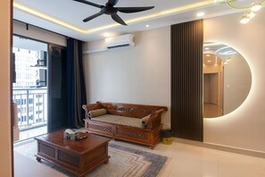 A modern living room with a sofa, coffee table, and a ceiling fan.