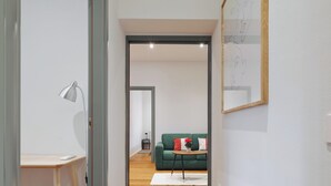 A modern living room with a green sofa, a small table with a vase, and a lamp. - Stylish 2BR flat in the city centre (Milan)