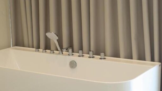 A modern bathroom with a freestanding bathtub, a showerhead, and a mirror. - ReiVal Hotel (Vlorë)