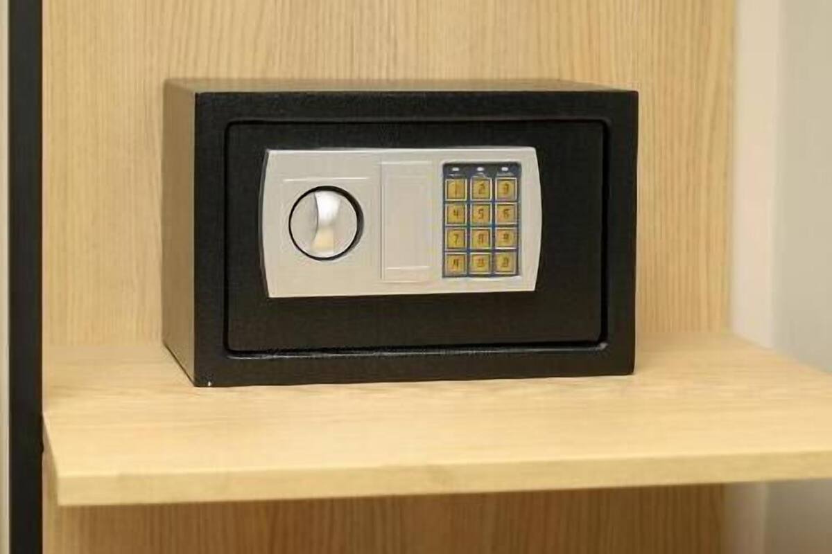 A safe deposit box on a wooden shelf.