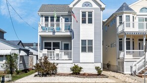 A two-story house with a balcony, a small porch, and a flag. - Top-Floor 3BR Ocean City w/ Porch + Parking (Ocean City)