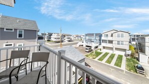 A residential area with multiple houses, a clear sky, and a balcony with chairs. - Top-Floor 3BR Ocean City w/ Porch + Parking (Ocean City)