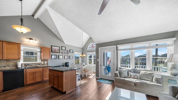 A spacious kitchen with wooden cabinets, a central island, and a dining area with a table and chairs. - Top-Floor 3BR Ocean City w/ Porch + Parking (Ocean City)