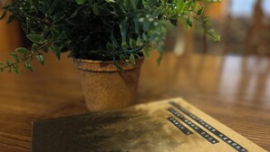 A notebook with a textured cover on a wooden surface.