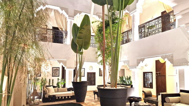 A spacious indoor area with a pool, large potted plants, and multiple seating areas. - Riad Dar El Mahja (Marrakech)