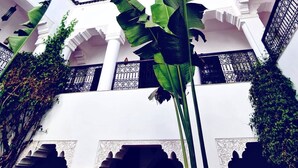 A courtyard with white columns, arches, and a clear blue sky. - Riad Dar El Mahja (Marrakech)