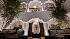 A lobby with a central seating area, a staircase, and decorative arches. - Riad Dar El Mahja (Marrakech)