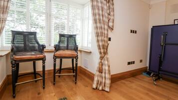 Una habitación con dos sillas, una ventana con persianas, una cortina y un armario morado.