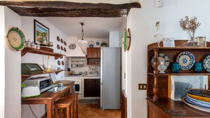 A kitchen with a wooden table, a refrigerator, and various kitchen appliances. - Casa Annibale con Vista Mare by Wonderful Italy (Palermo)
