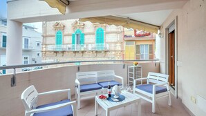 A balcony with white furniture, a bottle of wine, and a bowl of fruit. - Viadelmare Apartment Monopoli 200m Sea (Monopoli)