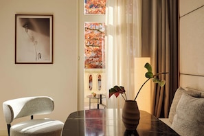 Habitación Deluxe doble, 1 cama de matrimonio grande, vistas al patio | Zona de estar | Una consola de videojuegos, libros, una estación de conexión para MP3