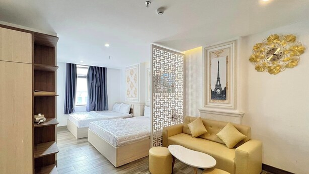 A hotel room with a bed, a sofa, a coffee table, and a wardrobe. - Lavender II Hotel (Da Nang)