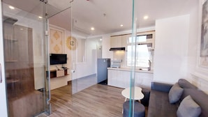 A modern apartment with a glass partition separating the living area from the kitchen. - Lavender II Hotel (Da Nang)