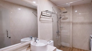 A modern bathroom with a large mirror, two sinks, a toilet, and a shower. - Lavender II Hotel (Da Nang)