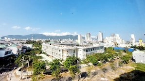 A cityscape with a prominent white building surrounded by greenery and other buildings. - Lavender II Hotel (Da Nang)