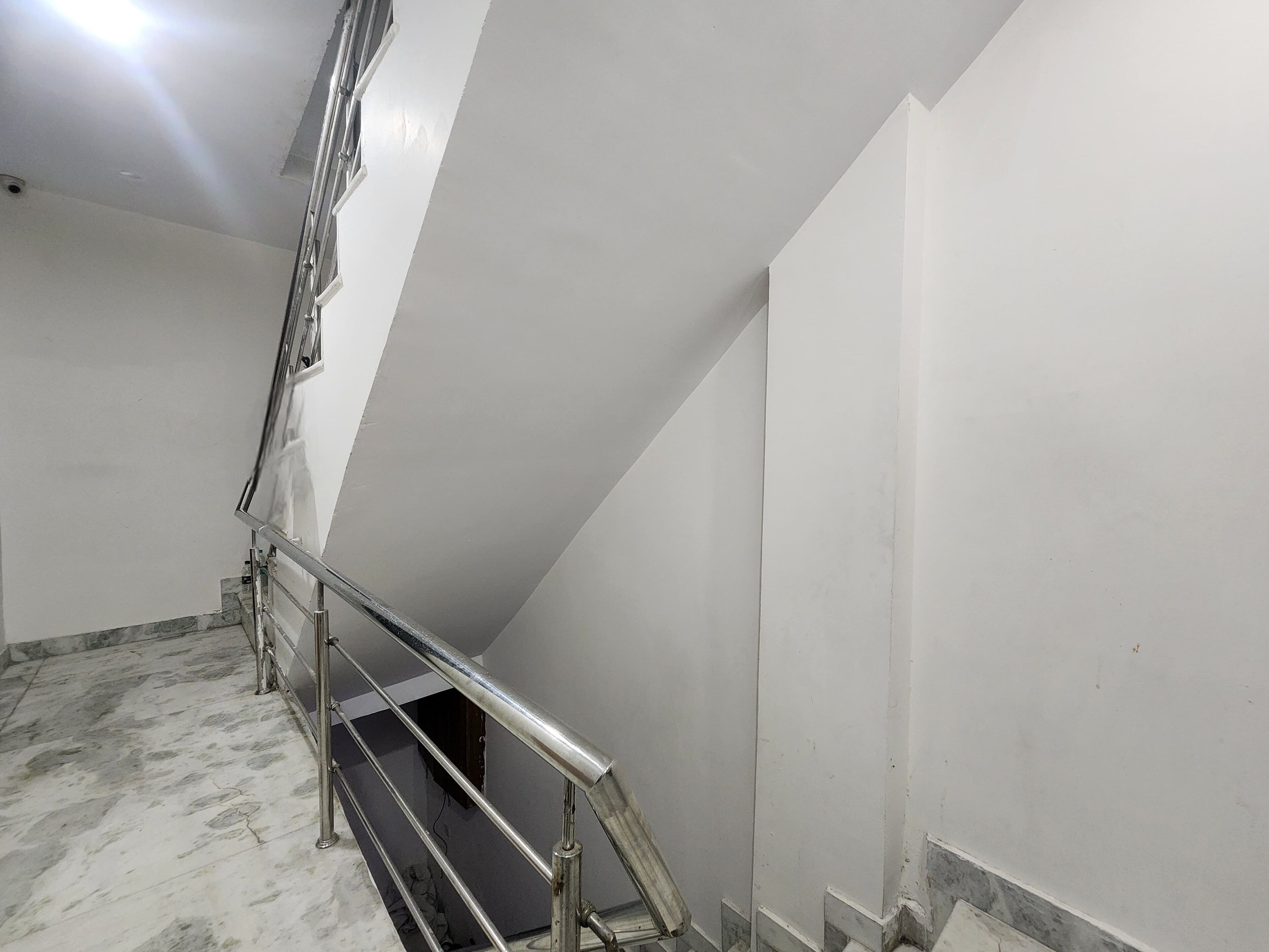A staircase with metal railings leading to a landing.